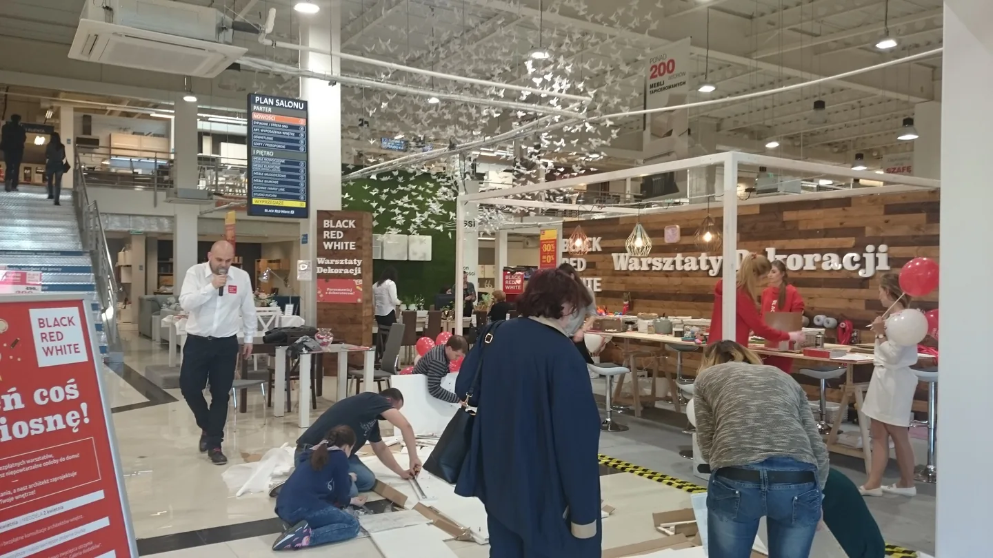 Prowadzący wydarzenie między stoiskami centrum handlowego